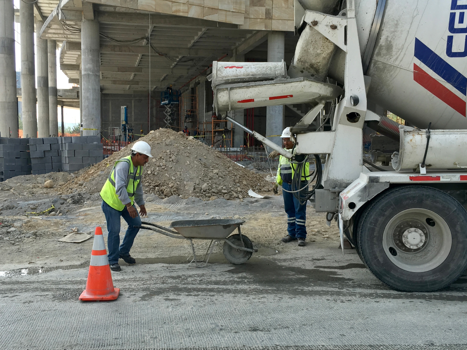 Workers unloading concrete on construction site